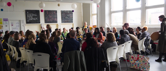 A room full of people, some holding musical instruments, sat on chairs in a circle at the UNESCO RILA Spring School 2019