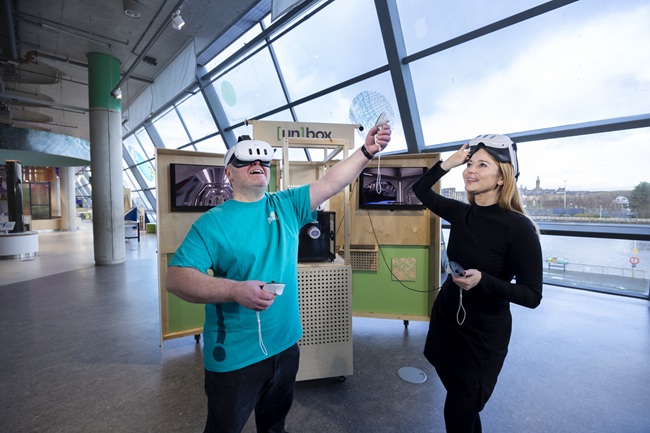 Dr Lynn Verschuren of the University of Glasgow’s Museums in the Metaverse team and Derek Shirlaw of the Glasgow Science Centre try out the un[box] VR kiosk at the Glasgow Science Centre. Credit Martin Shields