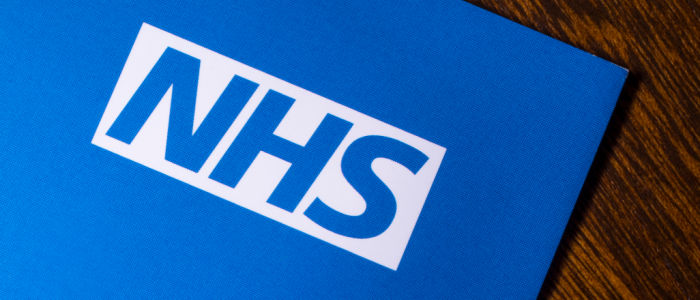 Photo of a file with the NHS logo on the front lying on a table