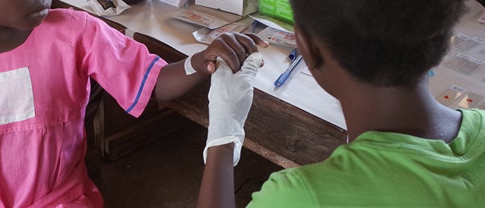 Finger prick blood test at a Ugandan clinic